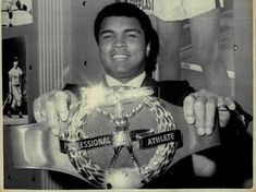 Muhammad Ali memegang sabuk juara dunia